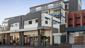 A modern multi-story building with a 'QUEST' sign, featuring balconies, large windows, and a mix of commercial and residential spaces. - Quest Ivanhoe (Ivanhoe)