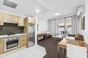 Uma cozinha moderna com forno embutido e área de jantar com mesa e cadeiras.