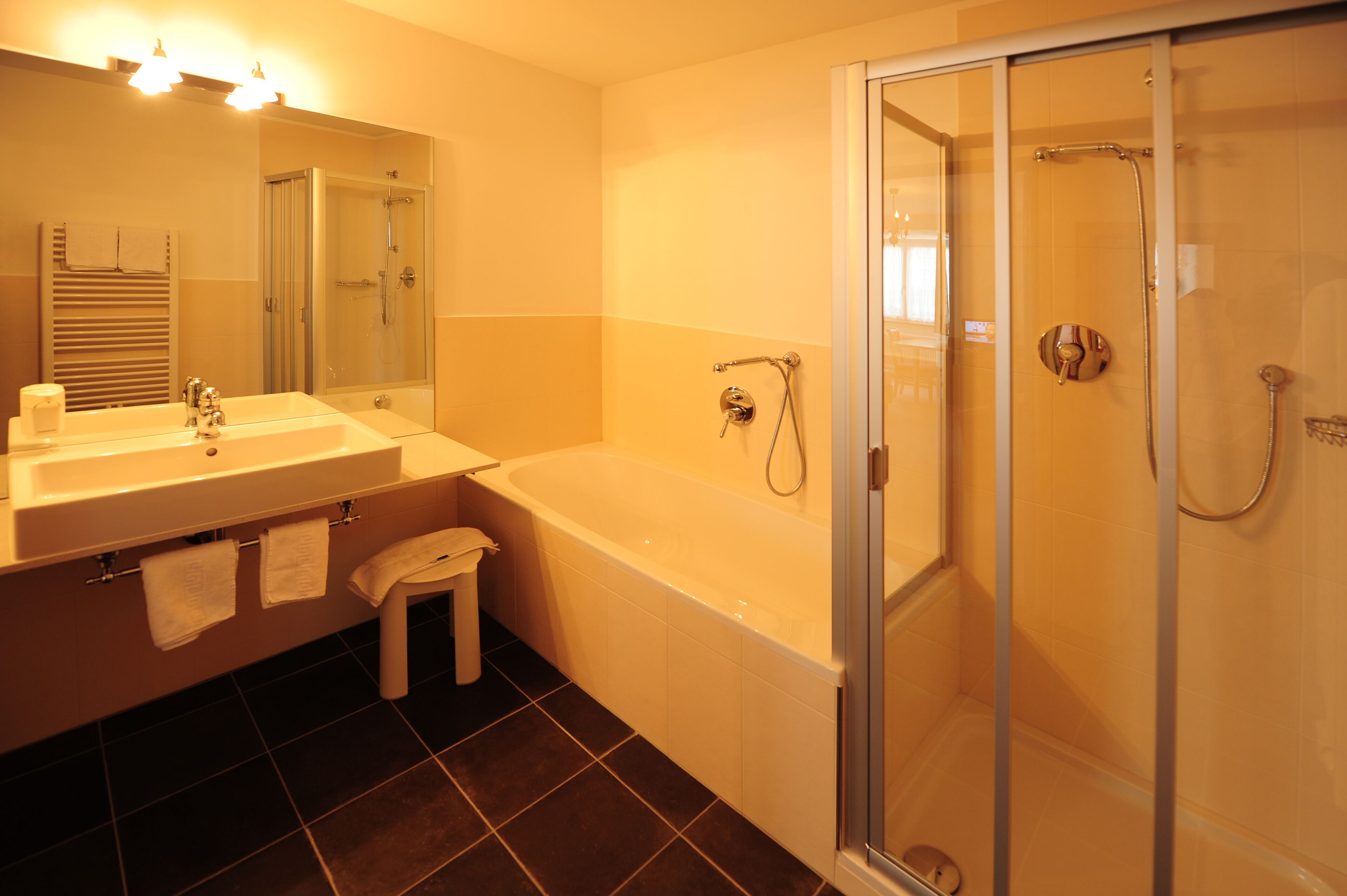 Ein modernes Badezimmer mit Badewanne, Dusche und Waschbecken.