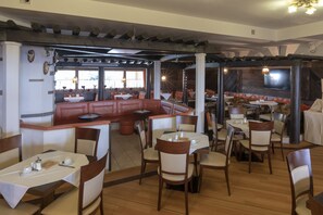 A restaurant with booths, tables, and chairs. - Hotel Krone (Matrei am Brenner)
