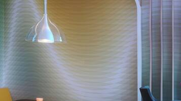 A modern interior with a curved wall, a table with chairs, and a pendant light.