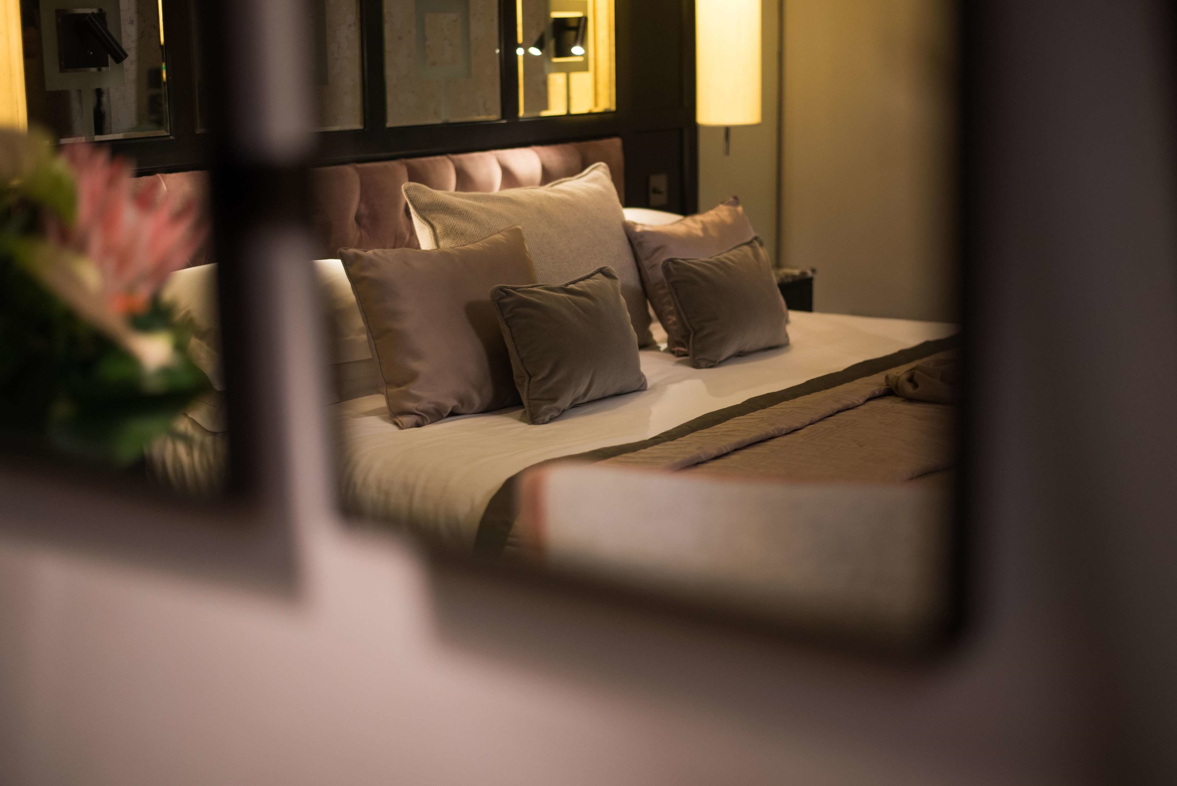A neatly made bed with multiple pillows and a headboard.