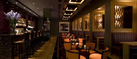 A modern bar area with seating and a bar counter.