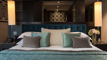A bedroom with a large bed, a dark headboard, and two bedside tables with lamps.