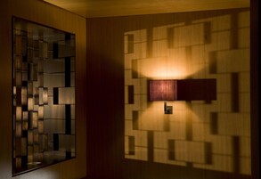 Un interior moderno con diseño geométrico en la pared y una superficie reflectante.