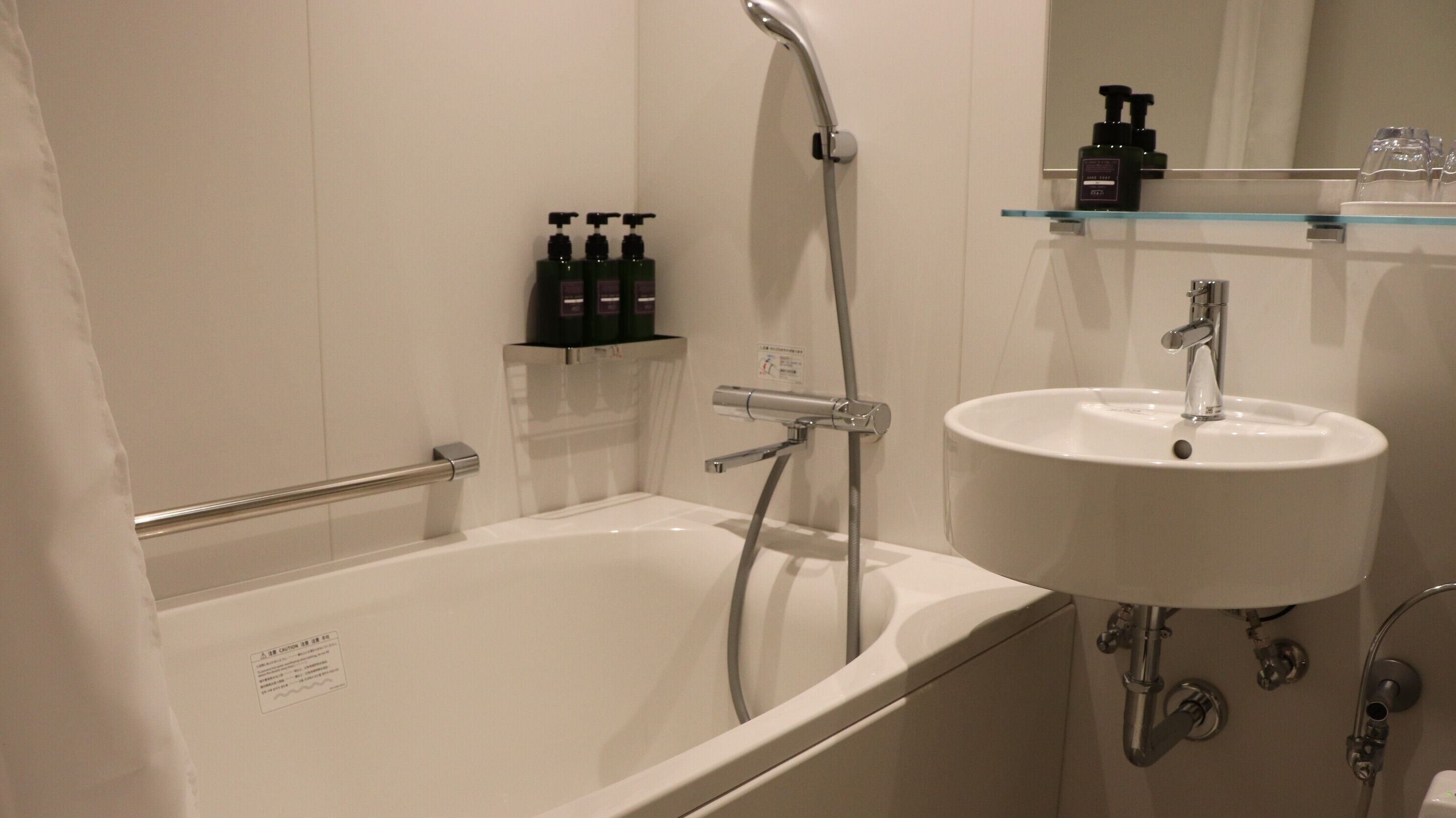 A modern bathroom with a bathtub, a sink, and a shower.