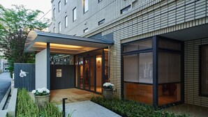 Un bâtiment moderne doté d’un porche, de grandes fenêtres et d’une façade en briques.