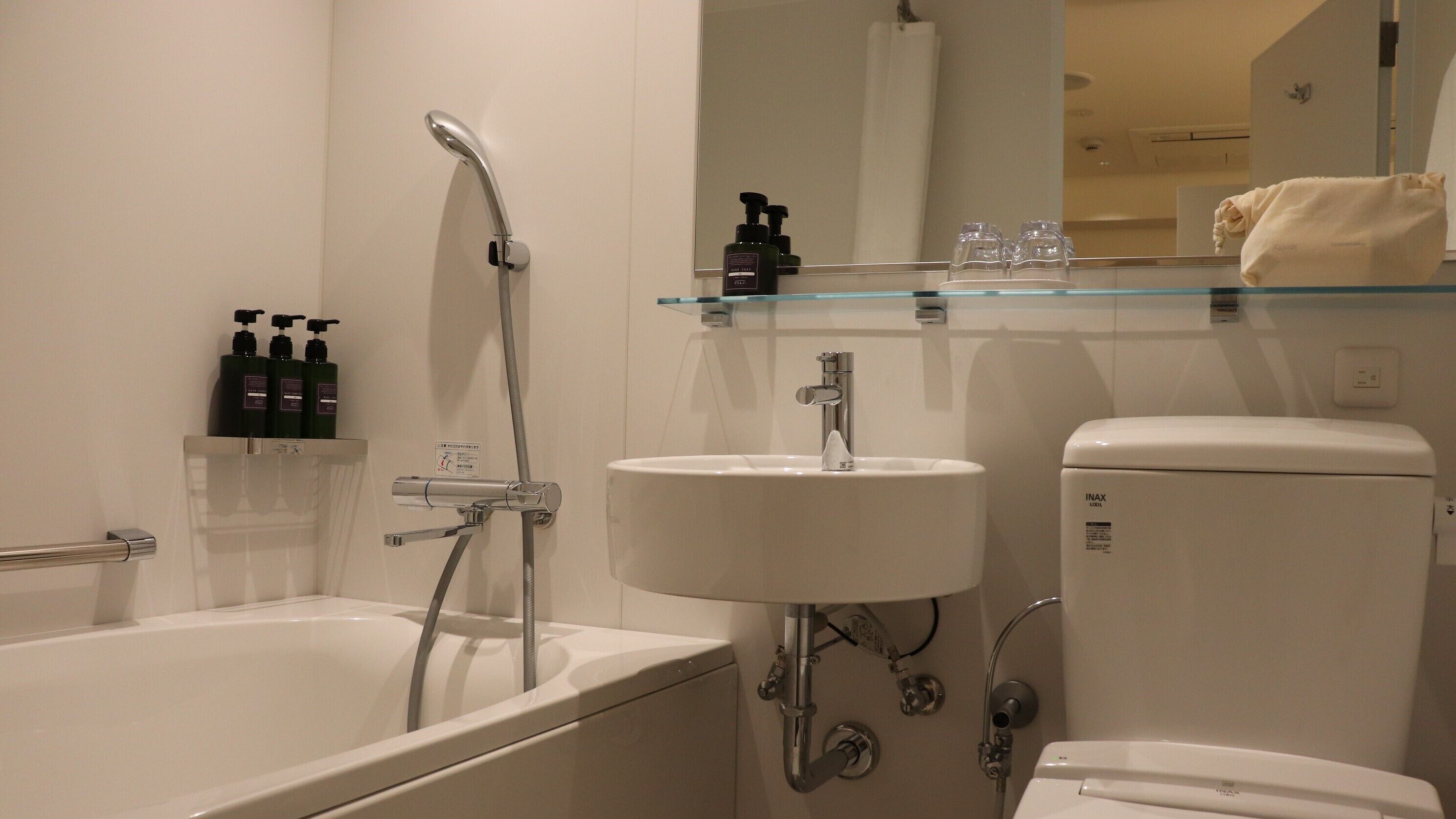 A modern bathroom with a bathtub, a sink, and a toilet.