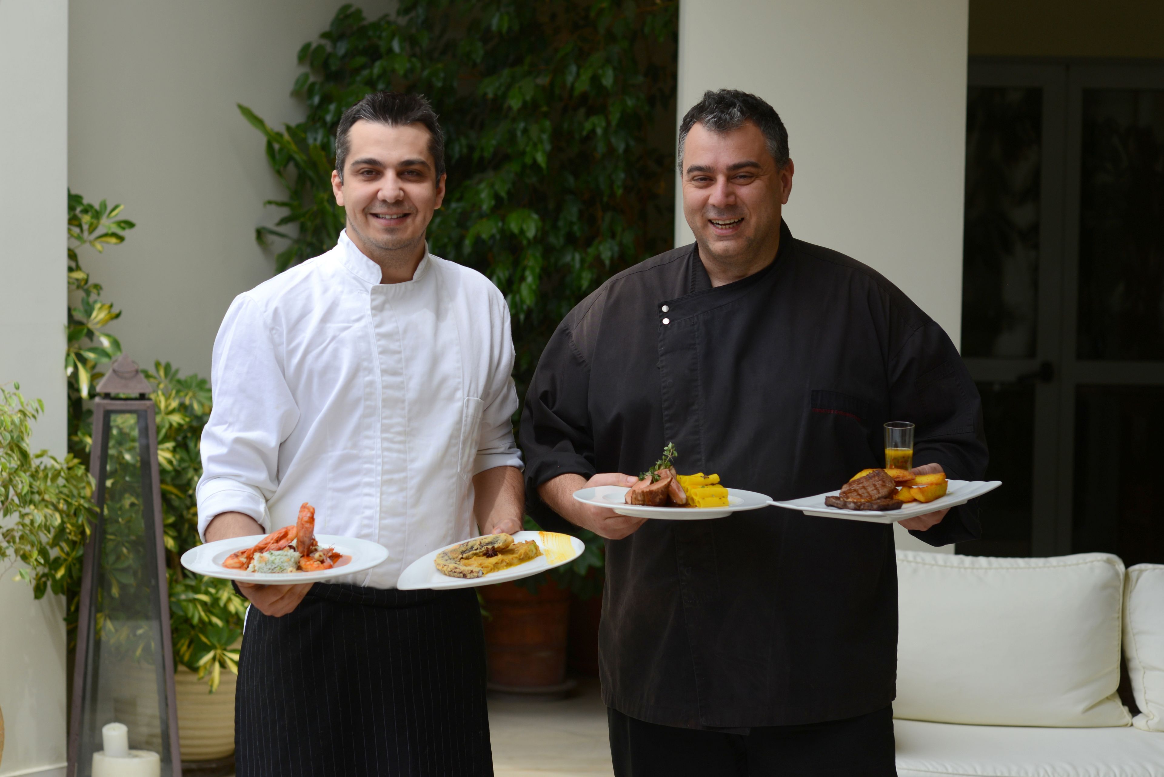 Due chef che tengono piatti di cibo.