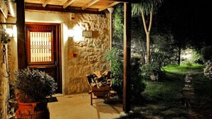 Un bâtiment en pierre avec une porte en bois et une entrée abritée.