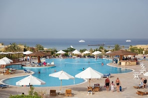 Een buitenzwembad, parasols voor strand/zwembad