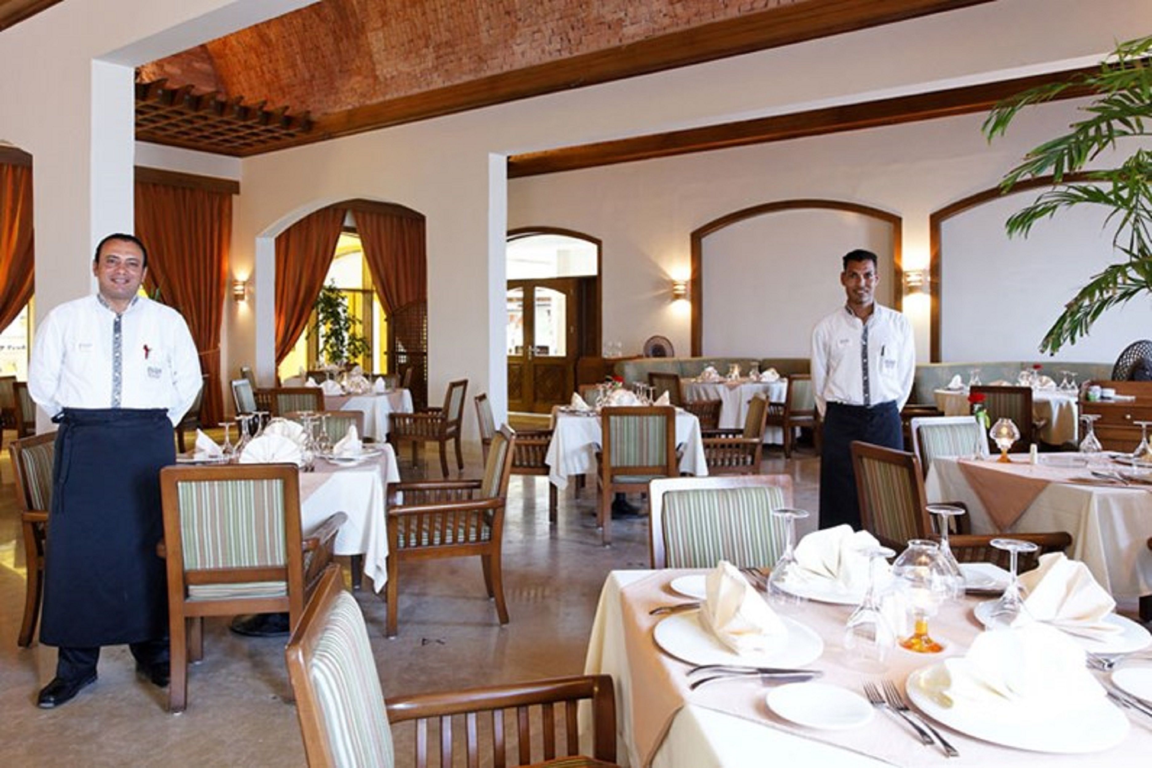 Un ristorante con arredamento in legno, tovaglie bianche e un'atmosfera accogliente.