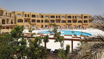 Una piscina al aire libre, sombrillas, tumbonas