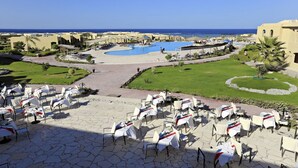 Ein Resort mit großem Pool, Sitzgelegenheiten im Freien und Blick auf den Ozean.