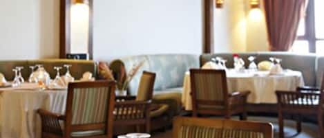 Un restaurante con mesas dispuestas para comer, con sillas de madera y un ambiente cálido.