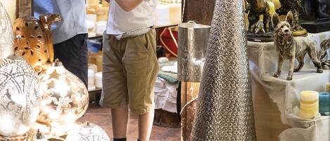 A shop with various decorative items and a child examining a small object.