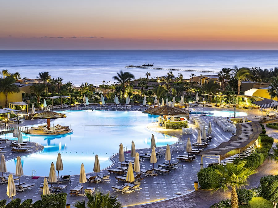 Alberca al aire libre, sombrillas en la alberca y camastros