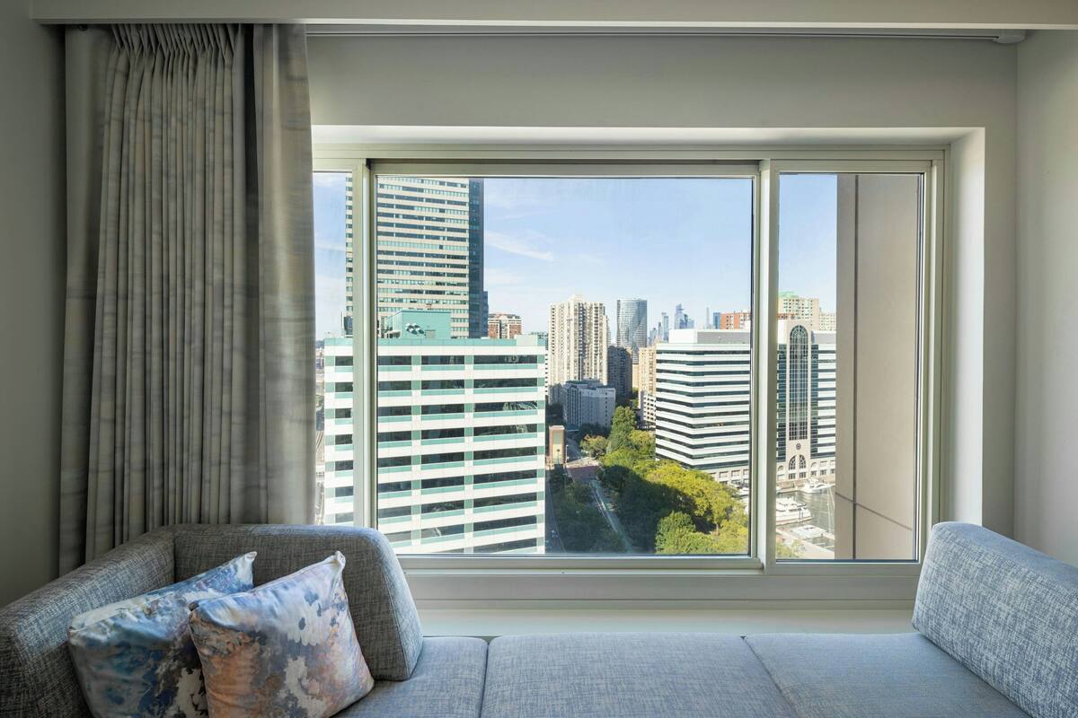 A modern living room with a large window offering a city view.