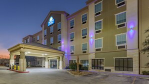 A hotel with a covered entrance, multiple floors, and a sign indicating it is a Days Inn & Suites. - Days Inn & Suites by Wyndham San Antonio near Frost Bank Center (San Antonio)