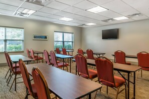 A conference room with tables and chairs, a flat-screen TV on the wall, and windows with blinds. - Country Inn & Suites by Radisson, Rossford - Toledo South (Perrysburg)