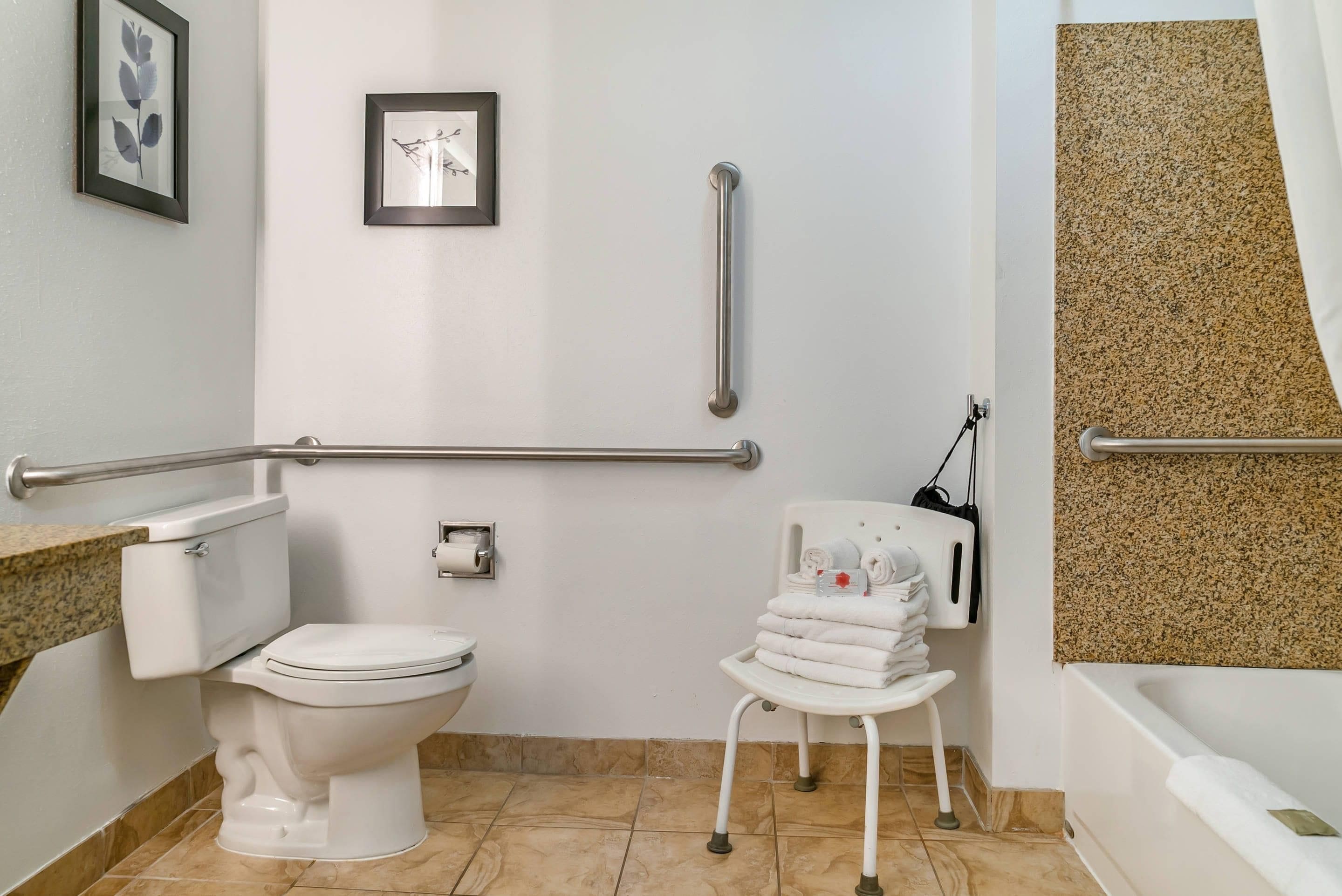 A bathroom with a toilet, a sink, a towel rack, and a grab bar.