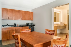 A compact kitchen with wooden cabinets, a microwave, and a coffee maker.