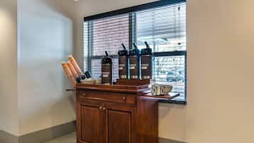 A kitchen area with a wooden counter, a window with blinds, and a water dispenser.