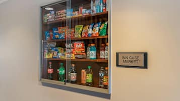 Una vitrina con la etiqueta 'INN CASE MARKET' que contiene varias botanas y bebidas.