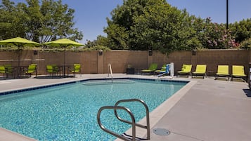 Alberca al aire libre, sombrillas en la alberca y camastros