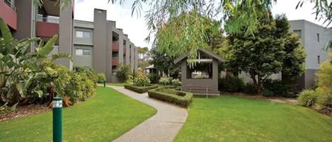 Un edificio residencial con un sendero que lleva a un pequeño jardín.