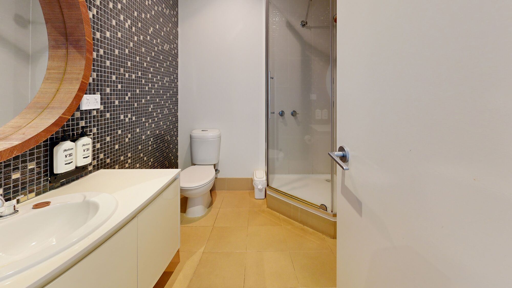 A bathroom with a white sink, a toilet, and a glass shower enclosure.