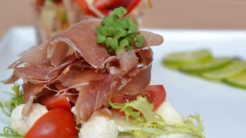 Un plato de comida con jamón serrano, tomates y lechuga.