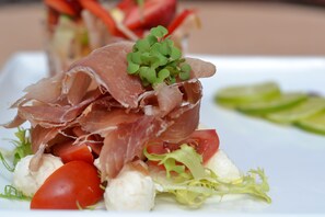 A plate of food with prosciutto, tomatoes, and lettuce. - Fletcher Hotel - Restaurant De Zalm (Brielle)