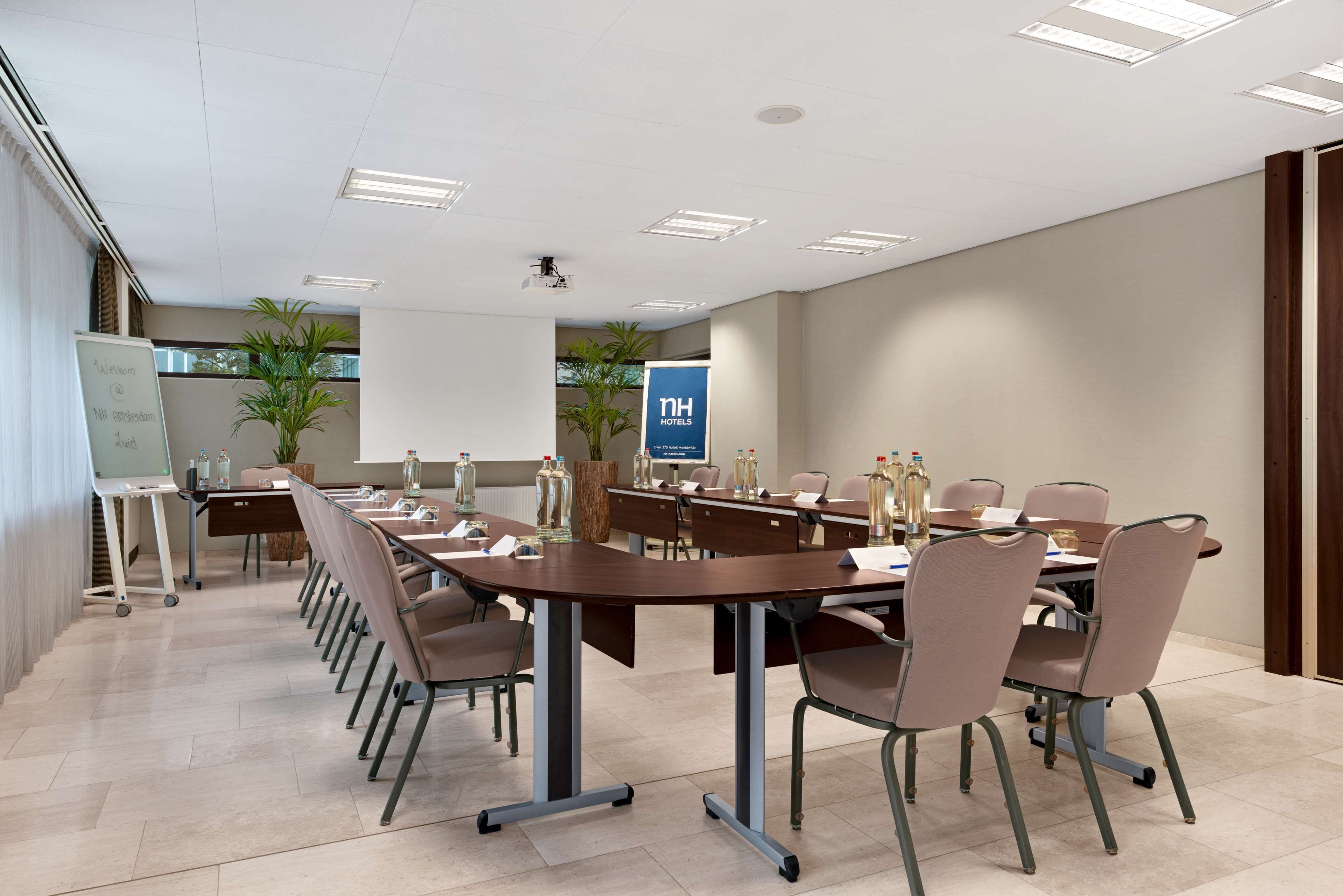 A conference room with a long table, chairs, and a whiteboard.