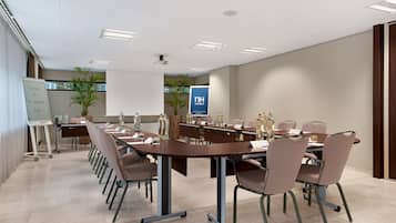 A conference room with a long table, chairs, and a whiteboard.