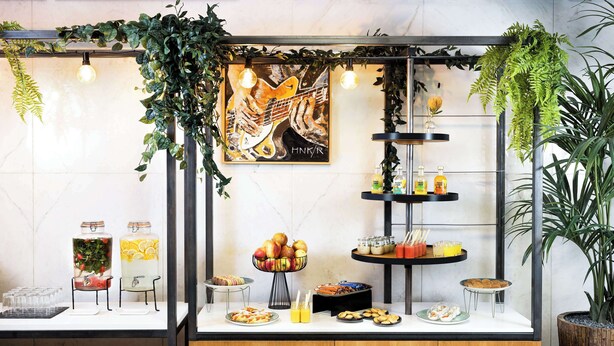 A breakfast bar with a variety of food items, including fruits, pastries, and beverages. - NH Amsterdam Zuid (Amsterdam)
