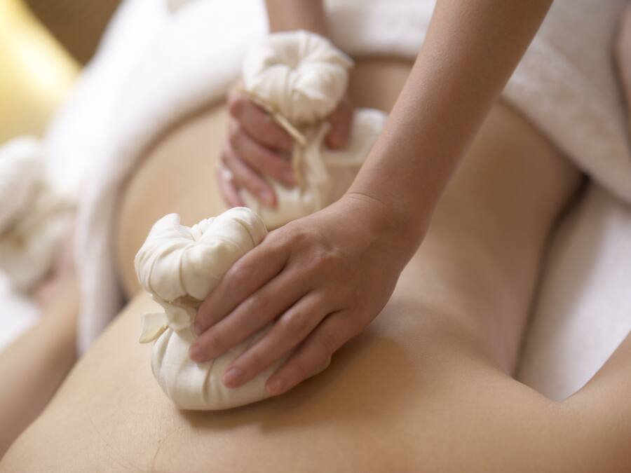 A massage with a white towel and a white cloth on a person's back.