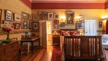 A traditional bedroom with a wooden bed, a desk, and a radiator.