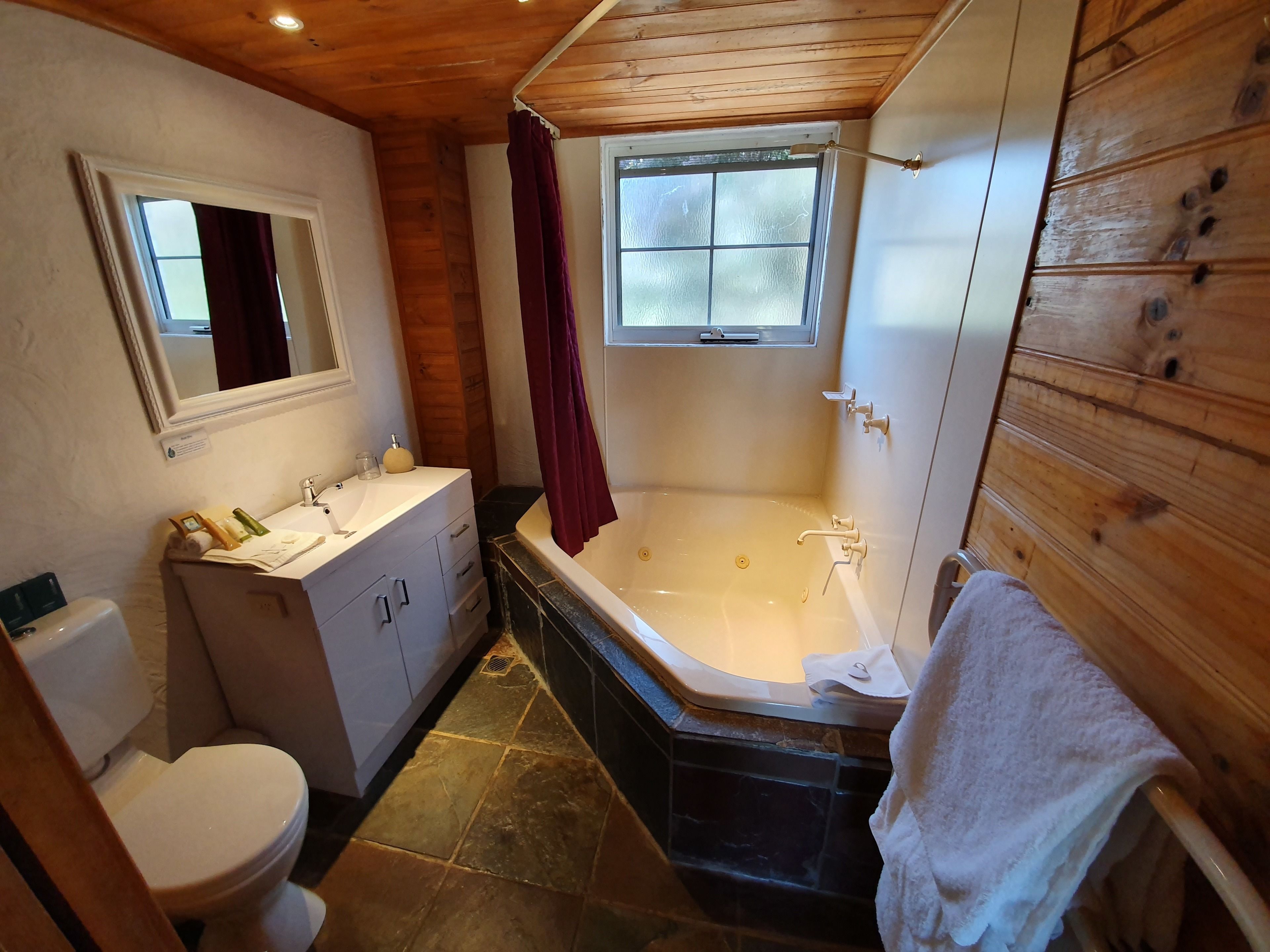 A bathroom with a toilet, sink, vanity, and a bathtub.