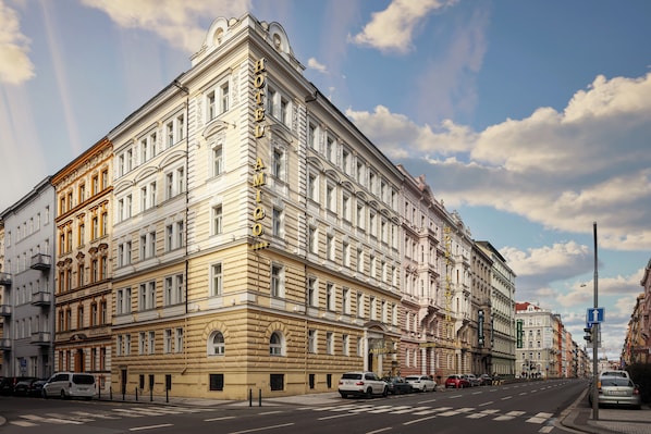 A multi-story hotel with classical architecture, a prominent entrance, and a street view with parked cars. - Amigo City Centre Hotel (Prague)