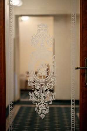 Une porte ornée de motifs complexes gravés sur du verre dépoli et dotée d’une poignée en métal.