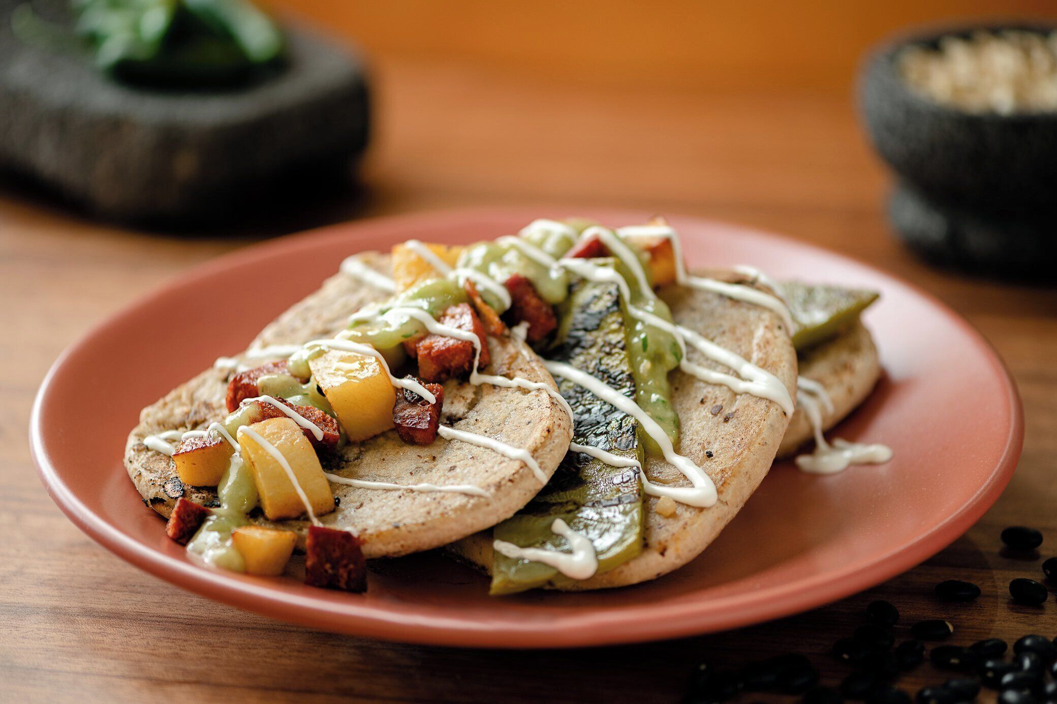A plate with two open-faced sandwiches topped with diced vegetables and a drizzle of sauce.