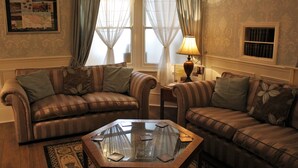 Una sala de estar con dos sofás a rayas, una mesa de centro de vidrio y una lámpara.