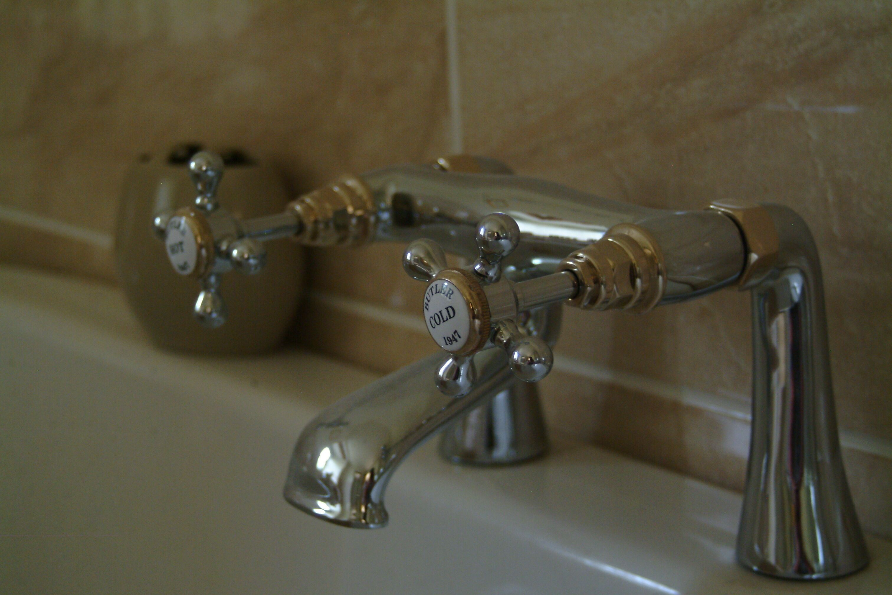 A bathroom with a bathtub and two faucets.