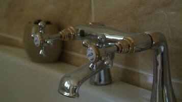A bathroom with a bathtub and two faucets.