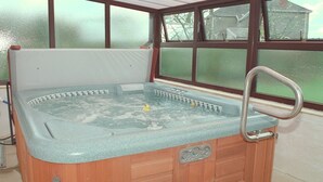 A wooden hot tub with a built-in seat and a metal faucet. - Greyfield Farm Cottages (Bristol)