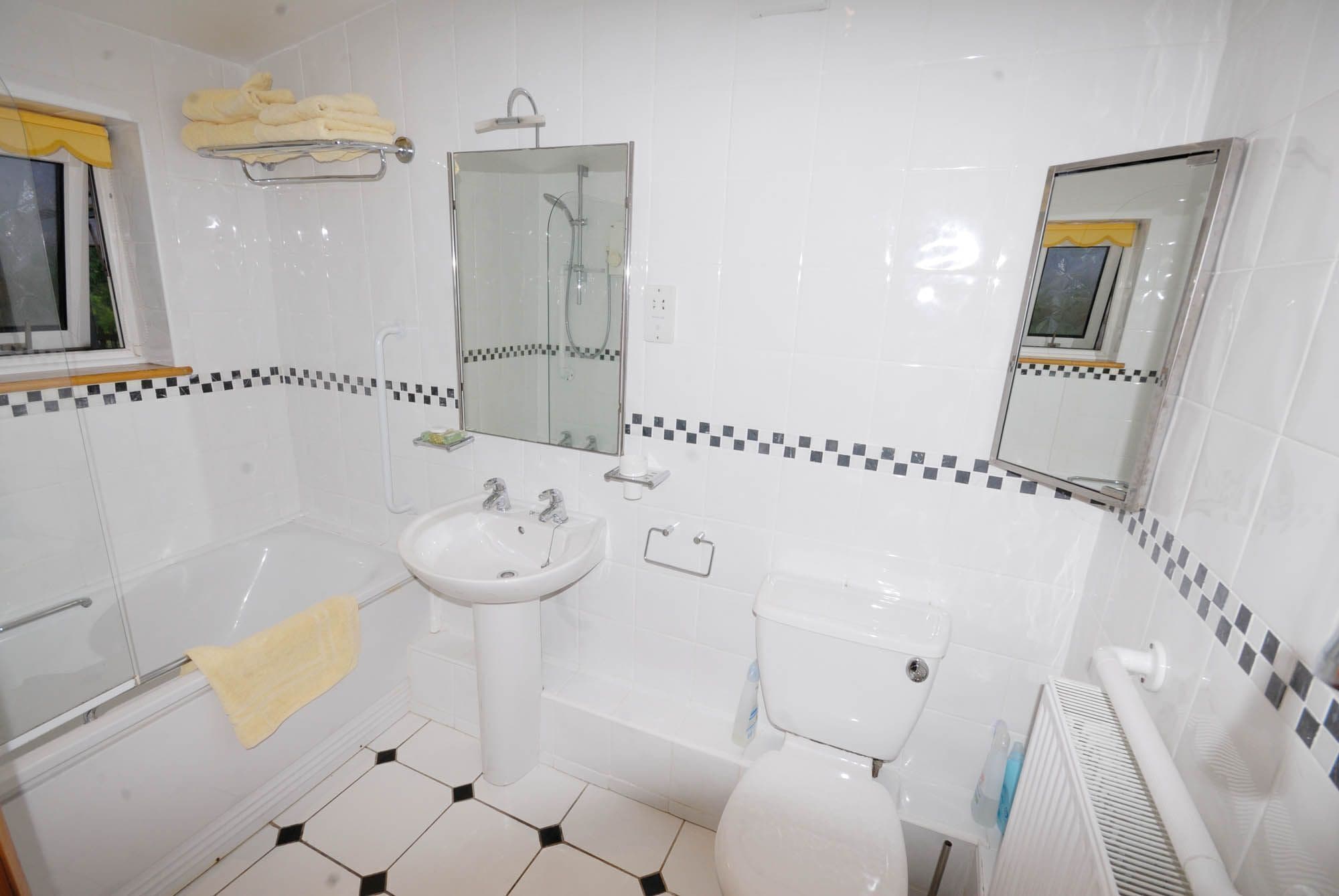 A bathroom with a sink, toilet, and shower.