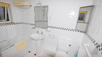 A bathroom with a sink, toilet, and shower.