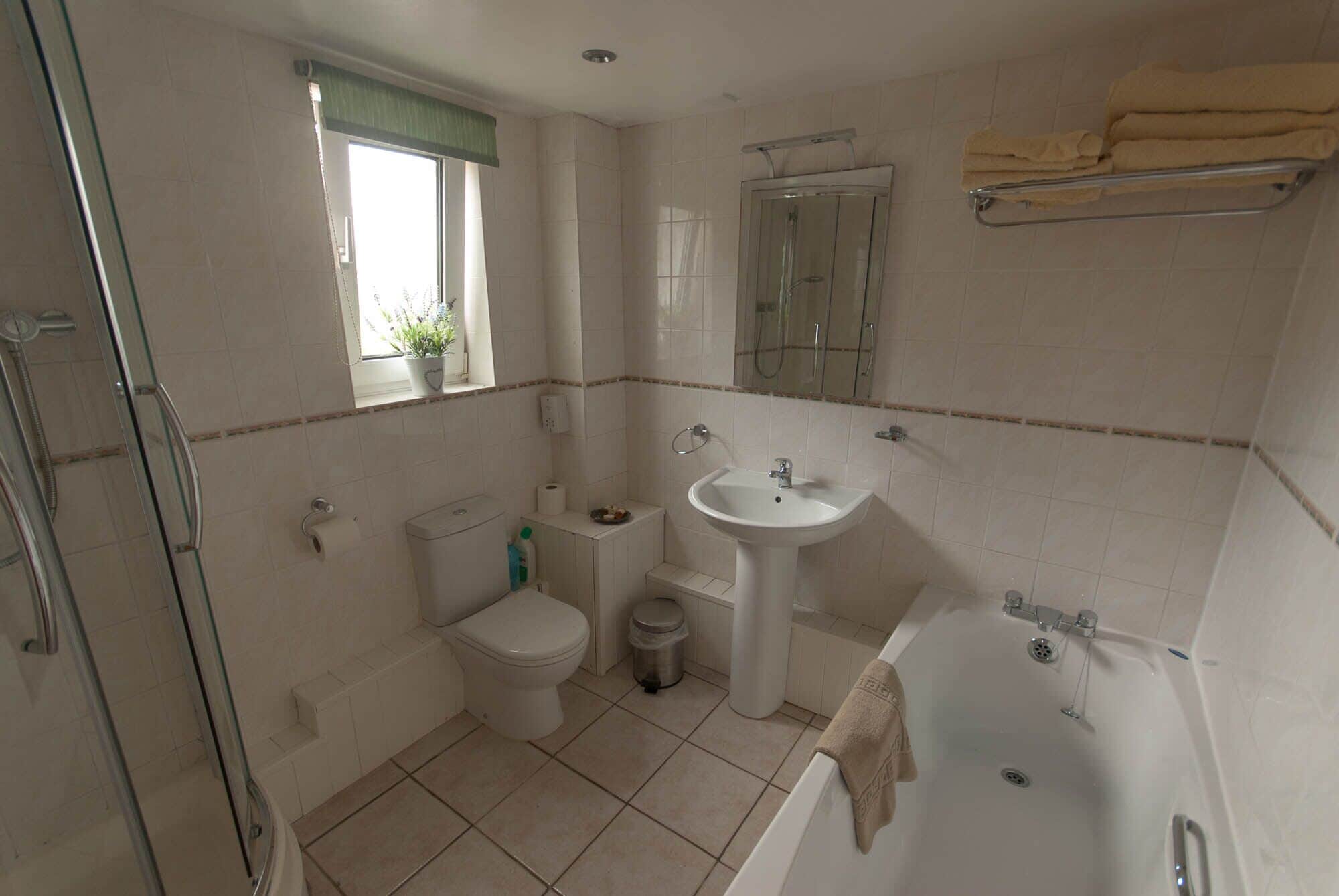 A bathroom with a toilet, sink, bathtub, and shower.