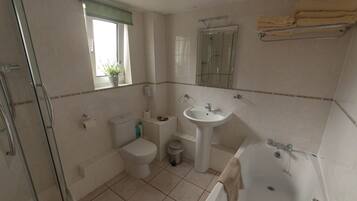 A bathroom with a toilet, sink, bathtub, and shower.
